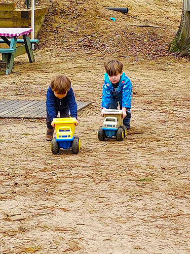 preschoolers playing with trucks